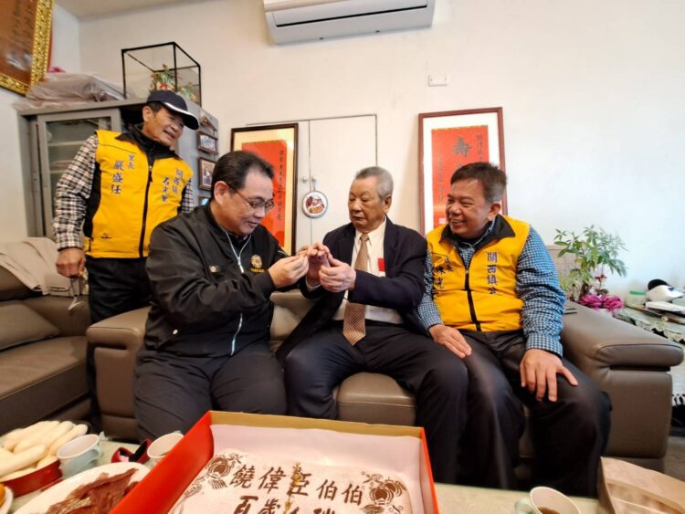 新竹榮服處鞠宗顯處長(前排左一)親自為饒爺爺戴上紀念金戒子。（圖/新竹榮服處提供）